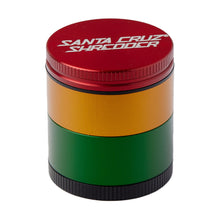 The Santa Cruz Shredder Medium 4-Piece Grinder is a medical-grade cylindrical herb grinder made from anodized aluminum, with four stacked sections in red, gold, green, and black and the logo on the top lid.