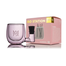 A translucent purple MJ Arsenal ISO Station sits next to its pink and yellow box, which displays product info and a line drawing of the cleaning tool holder.