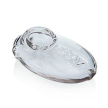The Grav Pebble Spoon features a clear glass, oval-shaped body with a raised circular holder and "GRAY" embossed on the surface, echoing its sleek smoking pipe design. Presented on a white background.