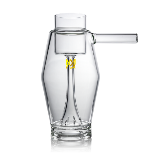 Set against a white background, the MJ Arsenal Proxy Bubbler features clear borosilicate glass with an angular body, a right-side cylindrical spout, and a yellow geometric logo on the front.
