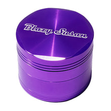 The Blazy Susan Grinder V2 is a shiny purple aluminum grinder with white script on the lid, faceted edge design, and a large grind chamber.
