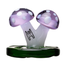 The Mushroom Carb Cap is a decorative borosilicate glass dab rig accessory, featuring two purple mushrooms with white spots joined on a green platform. Frosted stems and a black abstract design make it truly unique.