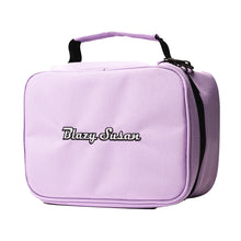 The Blazy Susan Stash Bag is a light purple, smell-proof bag with a black handle and zipper, featuring "Blazy Susan" embroidered in black and white—ideal for carrying essentials or pairing with a Blazy Susan rolling tray.