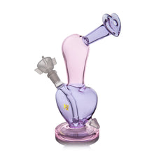 The MJ Arsenal Burning Heart (Valentine's 2024) is a purple borosilicate glass water pipe with a heart-shaped base, angled neck, and bowl piece, set on a thick round base—perfect as a limited edition Valentine's Day piece.