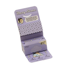 The Blazy Susan Purple Rolling Papers kit includes an 8-meter roll of king size slim papers and 50 tips in a lavender box, featuring illustrations, instructions, and a woman's face on the inner flap.