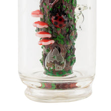 A close-up of the Empire Glass Works Renew the Redwood Peak Top, a borosilicate glass Puffco Peak attachment featuring a forest theme with tree trunk, red mushrooms, ladybug, green leaves, small frog, and etched flame and castle logo on the base.