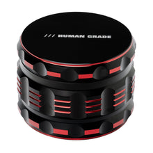 The Human Grade Grinder 5T (2.5") is a stylish and durable black and red aluminum 4-piece grinder with ridged sides and "HUMAN GRADE" printed in white on top.