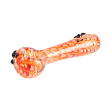 The Red Eye Glass 3.25" Zippy Glass Spoon is a travel-size hand pipe with swirling orange, red, and yellow patterns, crafted from durable borosilicate glass and accented with black on one end, shown isolated on a white background.