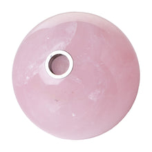 The Astral Project Globe Pipe is a round, polished pink gemstone pipe featuring a small circular metallic mesh opening at its center, seen from above and resembling a speaker or audio device.