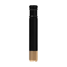 The MJ Arsenal Capsule Grinder Dugout is a black cylindrical metal accessory with a smooth upper section and ribbed golden lower end, shown standing upright against a white background.