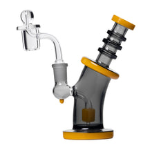 The Human Grade 6.25" Bent Neck Dab Rig is made from borosilicate glass, featuring a tilted black cylindrical body with yellow accents on the base, mouthpiece, and neck, plus a clear bowl and 14mm quartz bucket attachment.