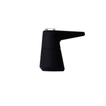A modern, matte black coffee maker with a sleek, angular design and short spout sits beside a SOFTGLASS PIER BUBBLER, both displayed against a plain white background.