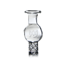 The MJ Arsenal Spinner Carb Cap is a clear glass bottle featuring a round body, narrow neck, double helix base design, and an etched stylized M logo on the front. Inspired by circular airflow in spinner carb caps or terp pearls; shown on white.