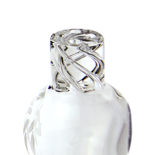 The MJ Arsenal Spinner Carb Cap features clear, smooth, and reflective glass with an intricately swirled design, resembling a decorative bottle stopper, shown against a white background.