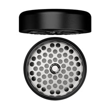 A black, round Flower Mill 2.5" Next Gen Premium Grinder with the lid off shows its mill plates and a perforated grinding surface featuring evenly spaced holes inside the milling chamber.