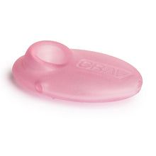 The Grav Sandblasted Pebble Spoon Pipe is a translucent pink, oval silicone hand pipe featuring a circular opening on one end and "GRAV" embossed on its matte finish.