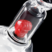 The MJ Arsenal x Tyson 2.0 Punch-Out is a borosilicate glass cone bubbler featuring a glass bottle design with a vibrant red head inside.