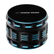 The Human Grade Grinder 5T (2.5") is a black and blue 4-piece aluminum grinder with textured sides and "HUMAN GRADE" printed on top, measuring 2.5" in diameter.
