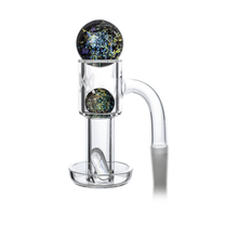 The MJ Arsenal Full Weld Quartz Terp Slurper is a clear glass dab rig attachment with a cylindrical chamber, two multicolored marbles, and engraved details. Pair it with a Terp Slurper Banger for enhanced sessions.