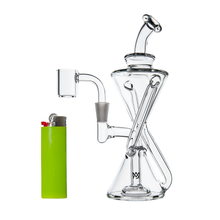 The MJ Arsenal Time Turner Mini Dab Rig, a clear glass hourglass-shaped piece with a side arm, stands beside a green lighter against a plain white background.