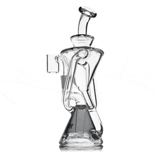 The MJ Arsenal Time Turner Mini Dab Rig is a clear borosilicate glass recycler with curved tubes, multiple chambers, a wide stable base, and side accessory attachment, blending modern artistic design for enhanced function and style.