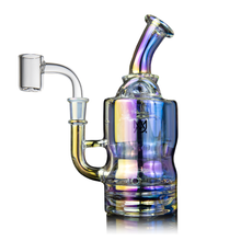 The MJ Arsenal Turbine Mini Dab Rig is made from iridescent borosilicate glass featuring a bent neck, wide base, clear quartz banger, and Inception Turbine Perc. Its glass reflects yellow, blue, and purple against a white background.