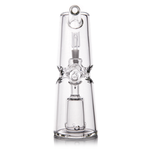 The MJ Arsenal Turret Mini Dab Rig, made of clear borosilicate glass with a cylindrical design, inner percolator, and straight mouthpiece, stands upright on a reflective surface.