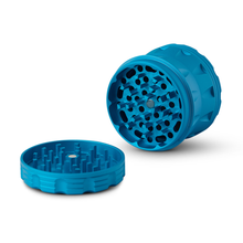 The Human Grade Grinder 2A (2.5" 4-Piece) is shown in blue, with one round piece flat to reveal sharp teeth and another upright to display matching interlocking teeth.