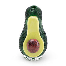 The Empire Glass Works Avocadope Peak Top is shaped like a halved avocado, with a textured dark green exterior, smooth yellow center, and red pit in the middle.