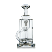 The MJ Arsenal Ursa Mini Dab Rig is a clear borosilicate glass rig featuring a cylindrical chamber, straight neck, flat base, and angled mouthpiece, shown against a white background.