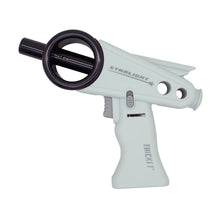 The Thicket Starlight Torch is a white and black ray gun toy with a retro-futuristic design, circular barrel detail, and rear fin, labeled "STARLIGHT" and "THICKET," reminiscent of a novelty torch lighter.