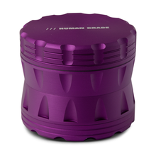 The Human Grade Grinder 2A (2.5" 4-Piece) is a metallic purple aluminum grinder with ridged edges, a pollen screen, and "HUMAN GRADE" printed on top.