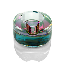 The Grav Ellipse Ashtray is a round, modern ashtray with an iridescent multicolored rim and transparent base—an eye-catching designer piece that enhances any space.