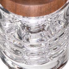 Close-up view of the MJ Arsenal Alpine Series - Halo Peak Top, showcasing its clear, textured borosilicate glass base with a wooden surface visible through the bottom.