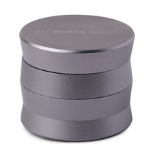 The Human Grade Grinder 3A (2" 4-Piece) is a metallic, cylindrical aluminum grinder with a matte finish and three stacked sections, featuring the words HUMAN GRADE faintly visible on its top lid.