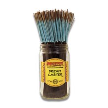 A glass jar displays Wild Berry Incense Sticks, 11" hand-dipped sticks with blue tips, standing upright. The yellow label features red and brown accents and is branded with the product name.