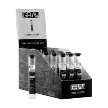 A GRAV 12mm Glass Tasters Display holds multiple 12mm glass tasters in clear tubes, with one upright taster pipe displayed in front of the black and white box labeled accordingly.