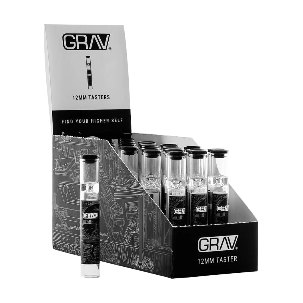 A GRAV 12mm Glass Tasters Display holds multiple 12mm glass tasters in clear tubes, with one upright taster pipe displayed in front of the black and white box labeled accordingly.