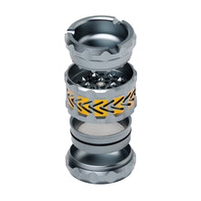 The Human Grade Grinder 8AT is a metallic 4-piece aluminum grinder featuring sharp teeth, a pollen screen, and arrow-shaped yellow accents, displayed exploded to reveal its separate components.