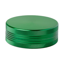 The 2 Piece Flat Grinder is a round, green metallic grinder with a textured grip and smooth top, shown on a white background. Also available in multiple colors.