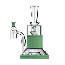 The Softglass Tandem Rig Kit is a modern vaporizer with a cylindrical glass and metal body, green platinum-cured silicone accents, an angled mouthpiece, and a side borosilicate attachment, shown against a white background.