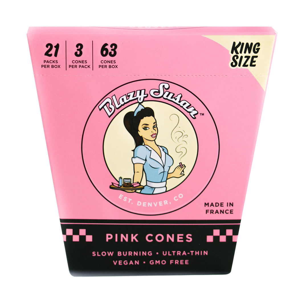 A pink box of Blazy Susan Pink Paper Cones features a cartoon woman and contains 21 packs with 3 king size pre-rolled cones each (63 total). The ultra-thin cones are slow burning, vegan, and GMO free.