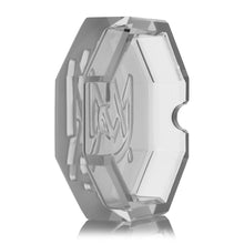 The MJ Arsenal Pegasus Ashtray is a clear, faceted, octagonal plastic piece with engraved front designs and a notched side indentation, shown standing upright against a white background.