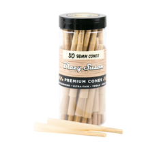 A clear plastic container labeled Blazy Susan Unbleached Paper Cones holds 50 unbleached, ultra-thin, vegan, slow-burning pre-rolled cones (98mm). Two cones are placed in front of the container.