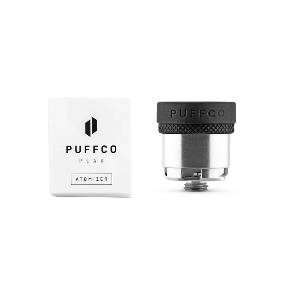 A Puffco Peak Atomizer with a ceramic bowl and its white box are shown side by side on a white background. The atomizer’s black top displays “PUFFCO,” while the packaging features the Puffco logo and “Peak Atomizer.”.