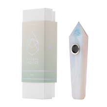 A pastel opal-inspired Gemstone Pipe with a replaceable mesh bowl rests beside its minimal white and light green Astral Project packaging.