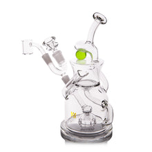 The MJ Arsenal The iLL-ien Dab Rig is a clear glass rig with multi-chamber design, bent mouthpiece, flat base, side arm for accessories, intricate tubing, and features green marble accents plus a spinning marble top.