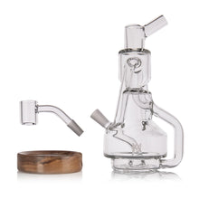 A clear glass MJ Arsenal Alpine Series - Apex Mini Rig with a detachable glass banger and round wooden base, displayed against a white background.