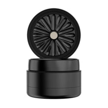 The Flower Mill 2.5" Next Gen Premium Grinder is a black, cylindrical grinder with a matte finish, textured lid, and sleek modern design. Its open lid displays sharp, curved mill plates inside for efficient grinding.