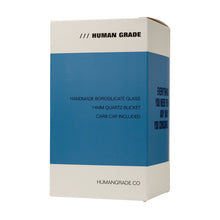A blue and white box labeled “HUMAN GRADE” with text: handmade Dualing Recycler Glass Rig Water Pipe, 14mm quartz bucket, carb cap included. The website humangrade.co appears at the bottom.